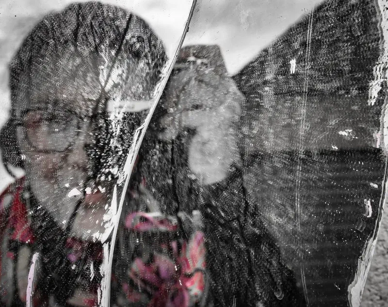 Autoportrait flou à travers une vitre griffée, comme une toile